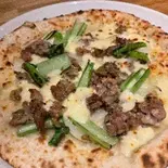 自家製ソーセージの玉ねぎと青菜 〜とろけるチーズ仕立て〜（本格イタリアン TRATTORIA AL MOMENTO）