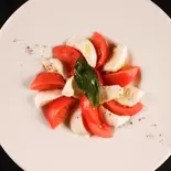 水牛モッツァレラとトマトのカプレーゼ（トラットリア クアルト 池袋店(写真は全てイメージです。表記以外の付け合せ等は日によって変更させて頂きます。)）