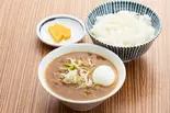 もつ煮込弁当 (カレー味)半熟玉子付（もつ煮定食よし川 新宿フロントタワー店）